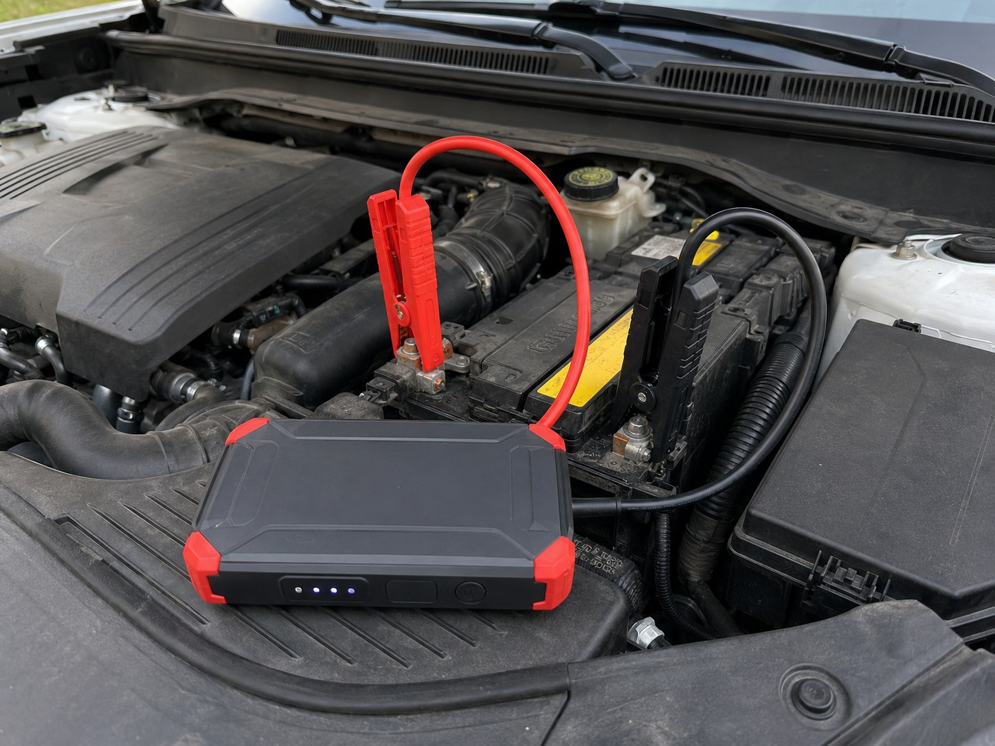 Jump starter pripojený k autobatérii v motorovom priestore