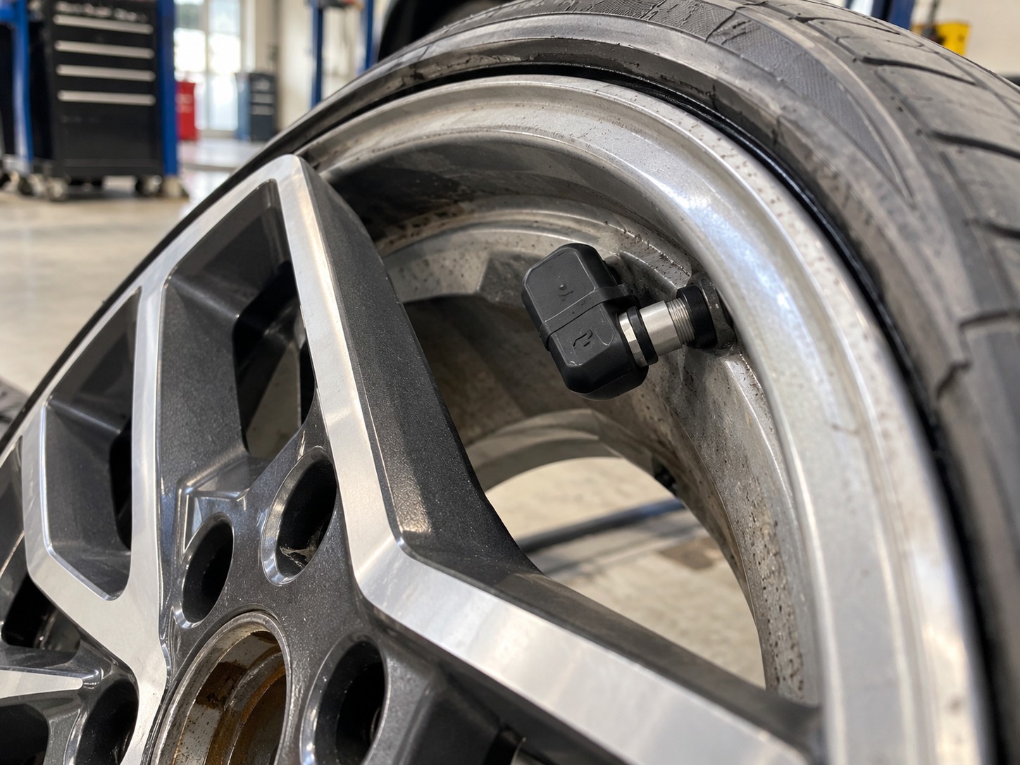 Detail vnútorného senzora priameho TPMS pripevneného k ventilu na disku automobilového kolesa.